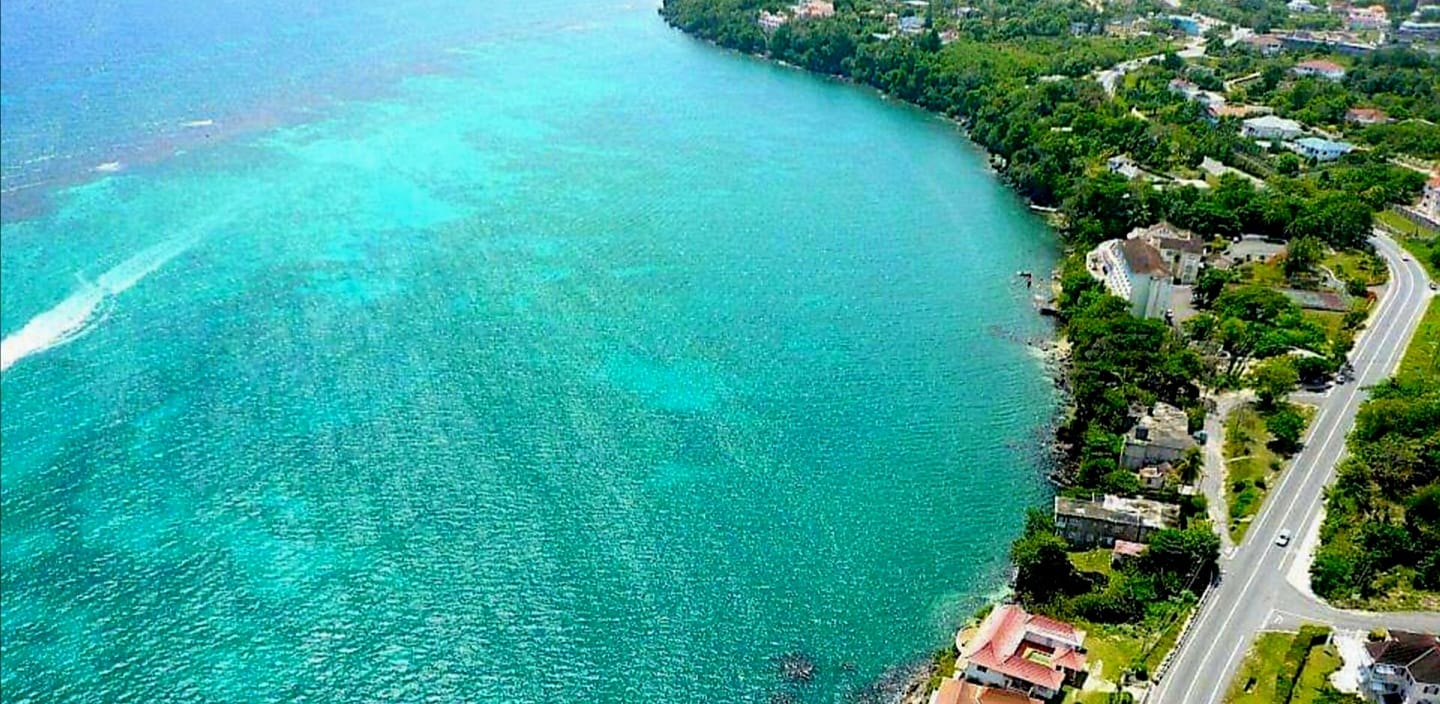 The Jamaican coastline. Red marker 1 indicates our office in the white building with the brown roof beside the sea. Red marker 2 indicates the nearby police headquarters towards the upper right.